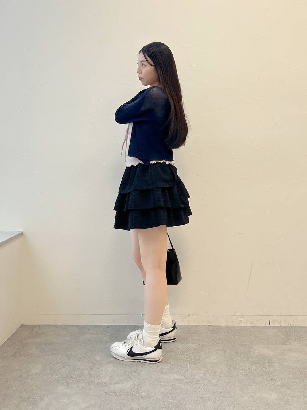 ピンク系のキャミソール、ブラック系のハンドバッグ、ブラック系のスカートを着用したレディースの夏コーディネートの4枚目の写真