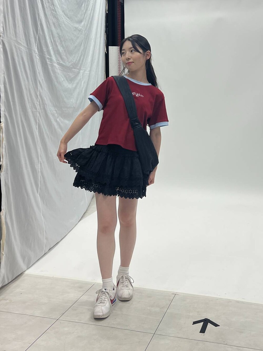 ブラック系のスカート、ブラック系のショルダーバッグを着用したレディースの夏コーディネートの2枚目の写真