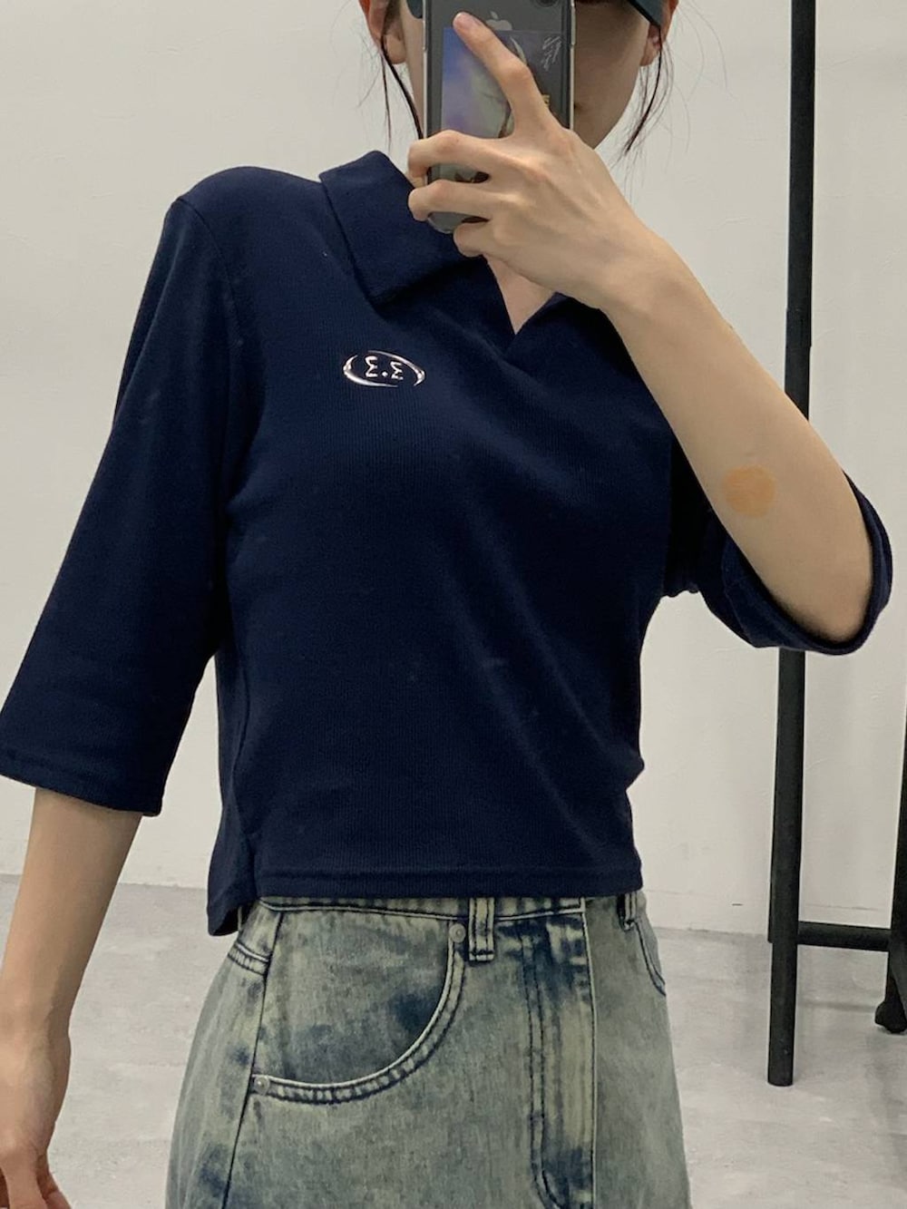 ブルー系のデニムスカート、ホワイト系のショルダーバッグ、ブルー系のTシャツ/カットソーを着用したレディースの秋コーディネートの4枚目の写真