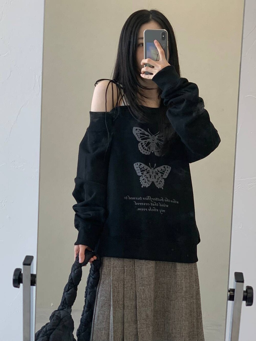 ブラック系のショルダーバッグ、ブラウン系のスカート、ブラック系のスウェットを着用したレディースの冬コーディネートの5枚目の写真