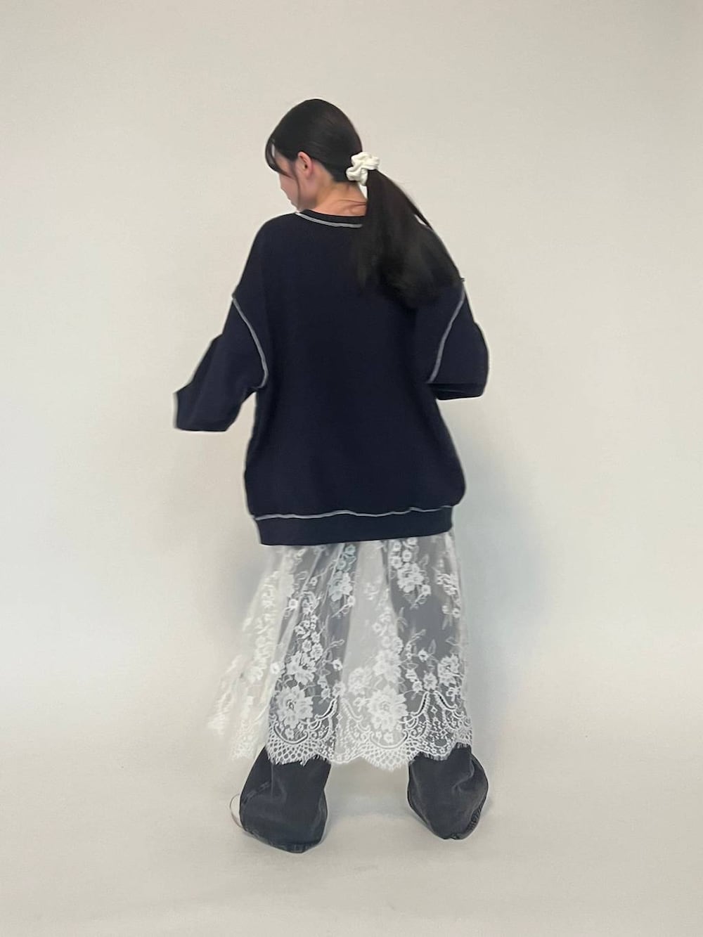 ブラック系のデニムパンツ、ブルー系のパーカー、ホワイト系のスニーカーを着用したレディースの冬コーディネートの3枚目の写真