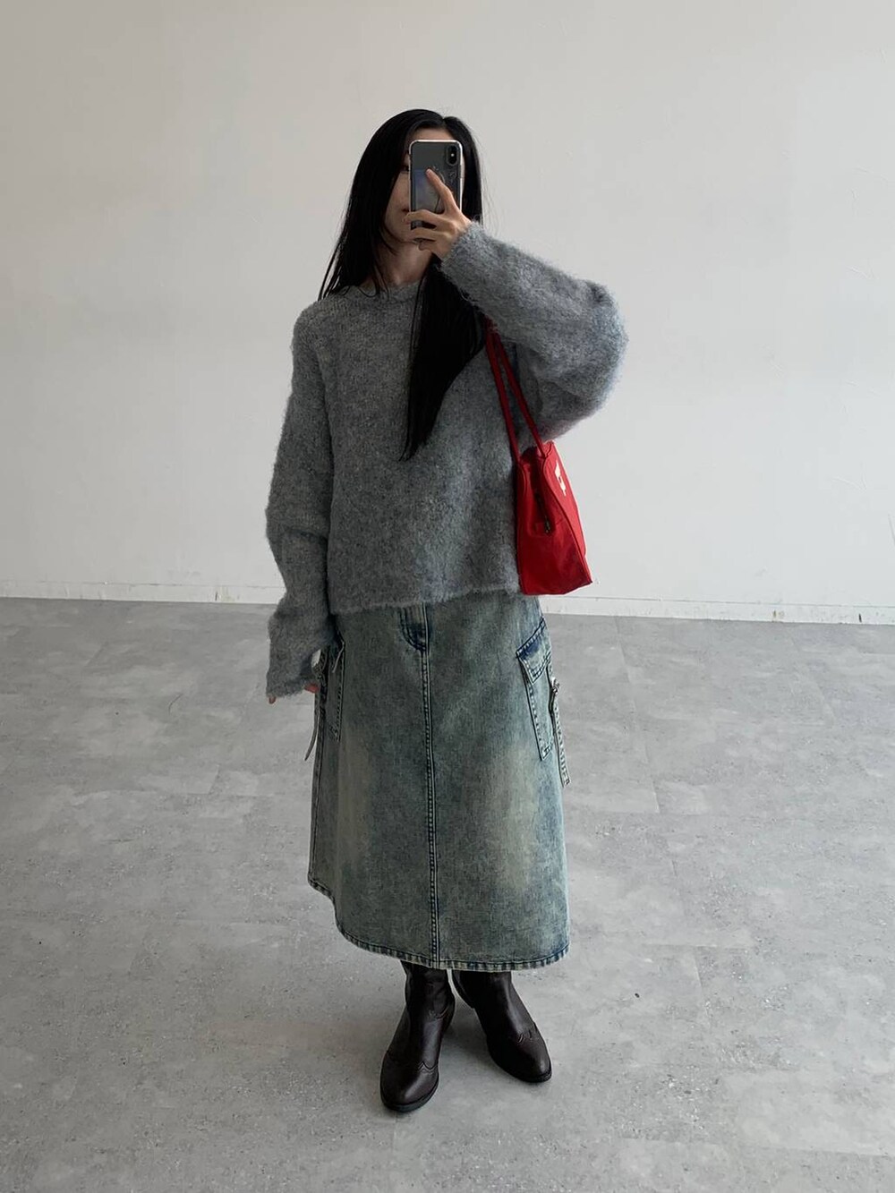 ブルー系のデニムスカート、グレー系のニット/セーターを着用したレディースの秋コーディネートの3枚目の写真