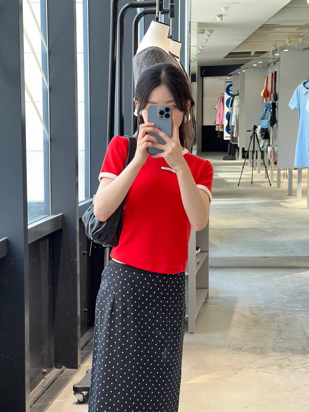 ブラック系のトートバッグ、ブラック系のスカート、レッド系のTシャツ/カットソーを着用したレディースの夏コーディネートの5枚目の写真