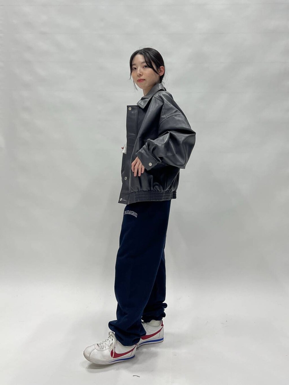 グレー系のブルゾン、ホワイト系のスニーカー、ブルー系のスウェットパンツを着用したレディースの冬コーディネートの5枚目の写真