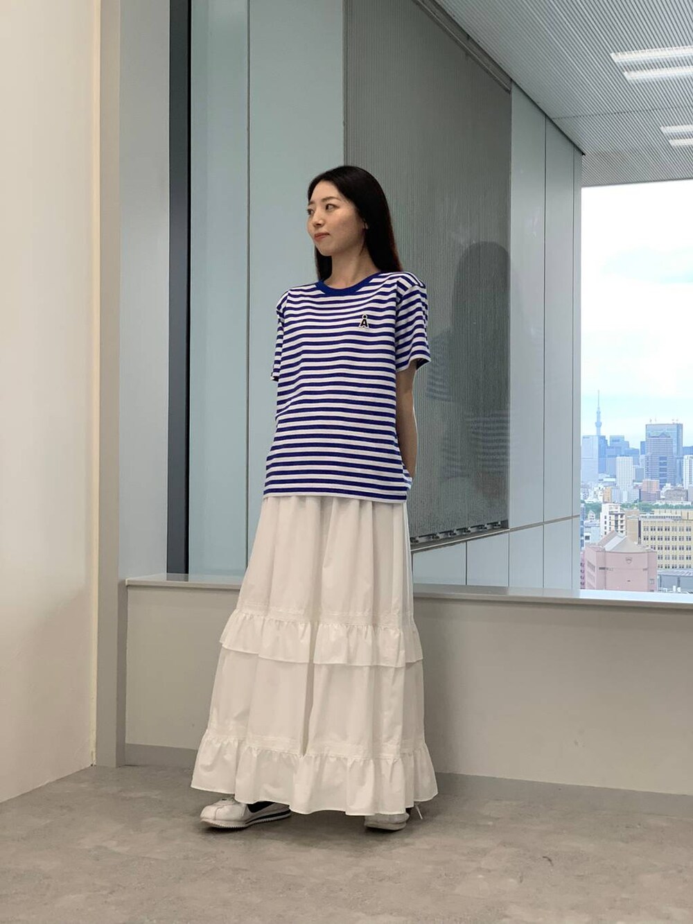 ホワイト系のスカート、ブルー系のTシャツ/カットソーを着用したレディースの夏コーディネートの2枚目の写真