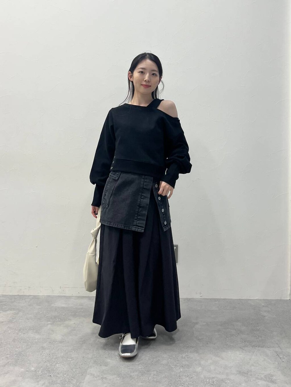 ブラック系のスカート、ブラック系のデニムパンツを着用したレディースの春コーディネートの2枚目の写真