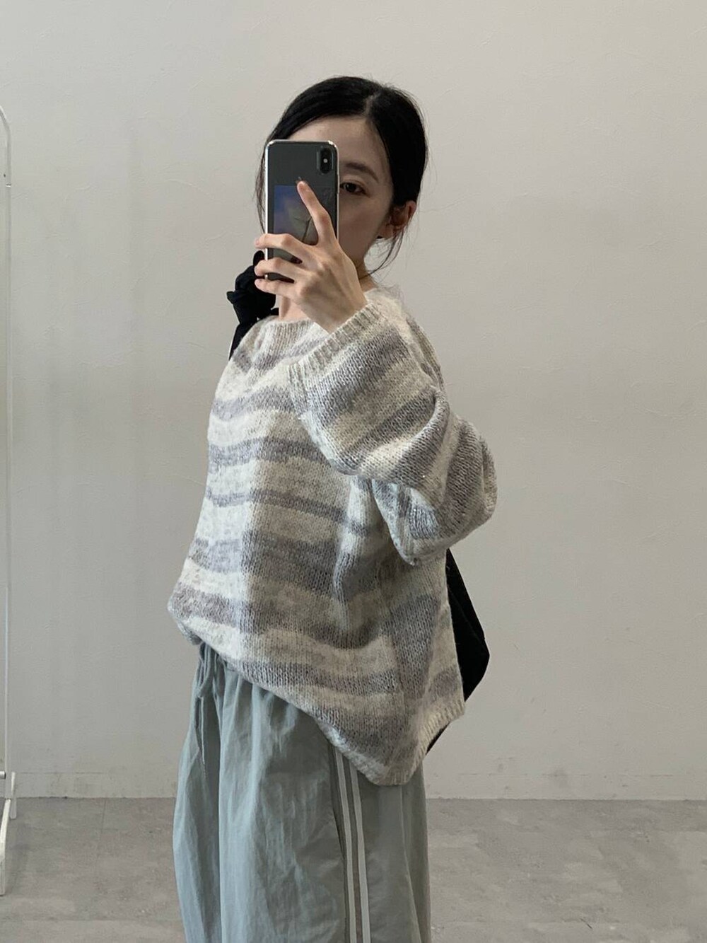 グレー系のその他パンツ、ブラック系のショルダーバッグ、グレー系のニット/セーターを着用したレディースの秋コーディネートの6枚目の写真