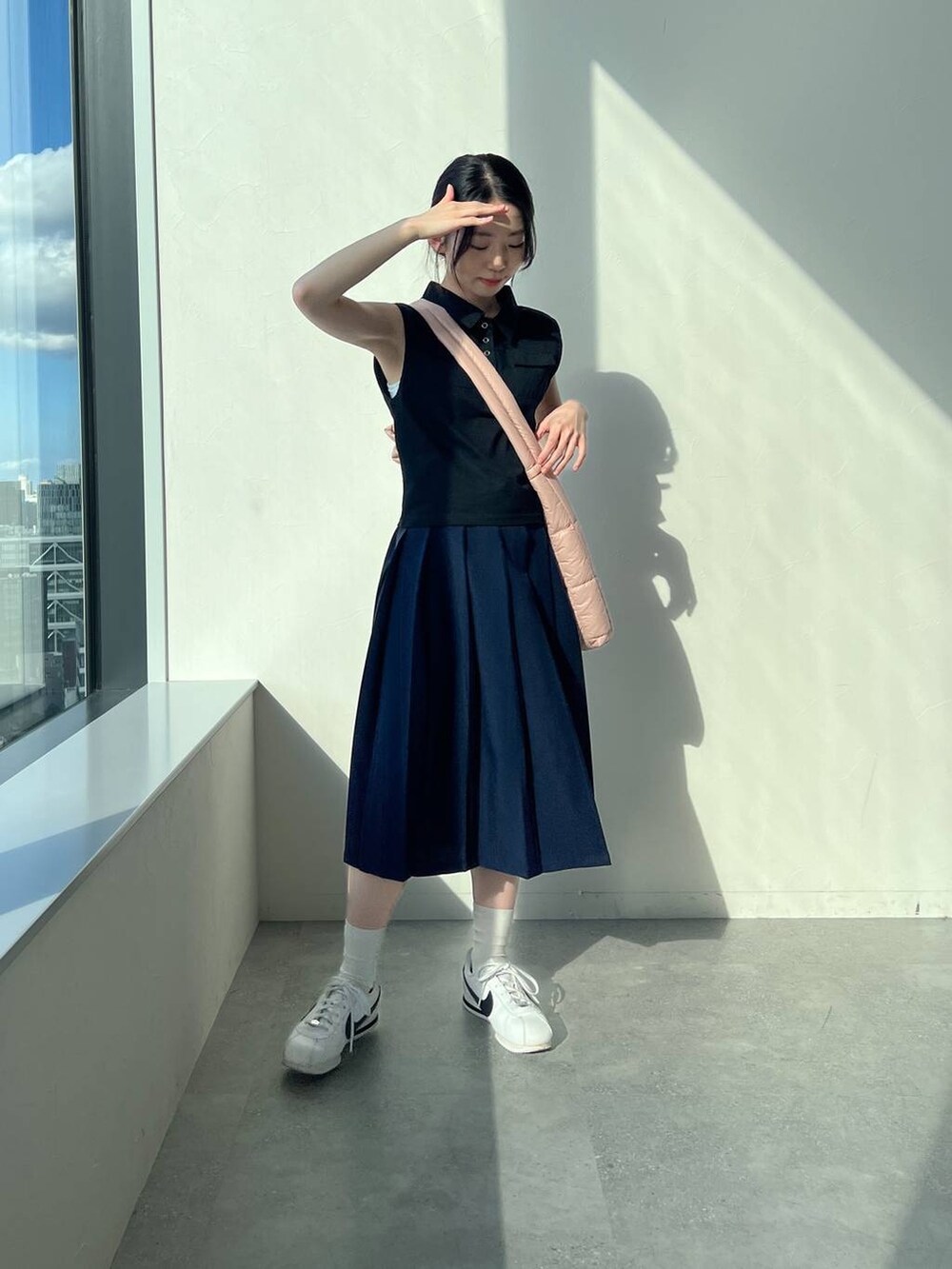 ブルー系のスカート、ピンク系のショルダーバッグ、ブラック系のタンクトップを着用したレディースの夏コーディネートの7枚目の写真