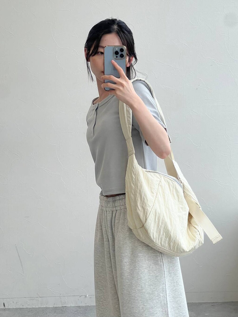 グレー系のスウェットパンツ、ベージュ系のショルダーバッグ、ブルー系のTシャツ/カットソーを着用したレディースの夏コーディネートの3枚目の写真