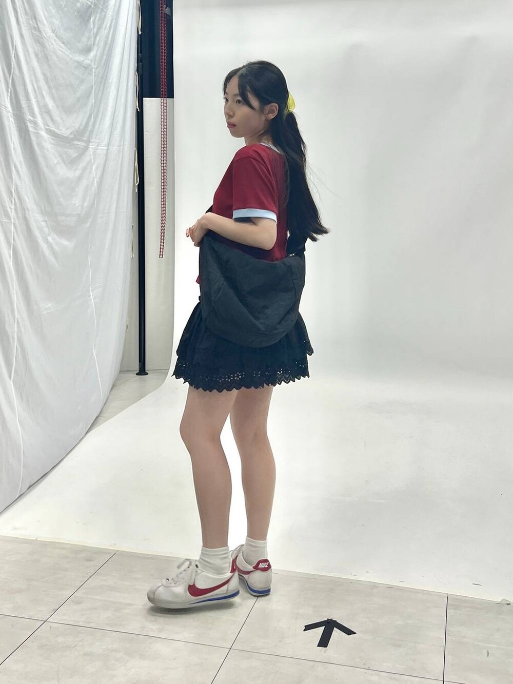 ブラック系のスカート、ブラック系のショルダーバッグを着用したレディースの夏コーディネートの3枚目の写真