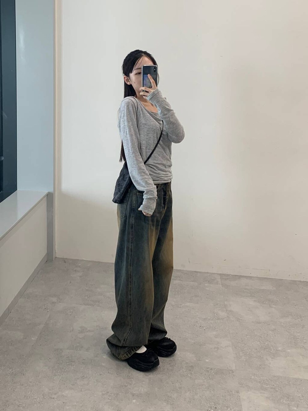 ブルー系のデニムパンツ、グレー系のTシャツ/カットソーを着用したレディースの秋コーディネートの2枚目の写真