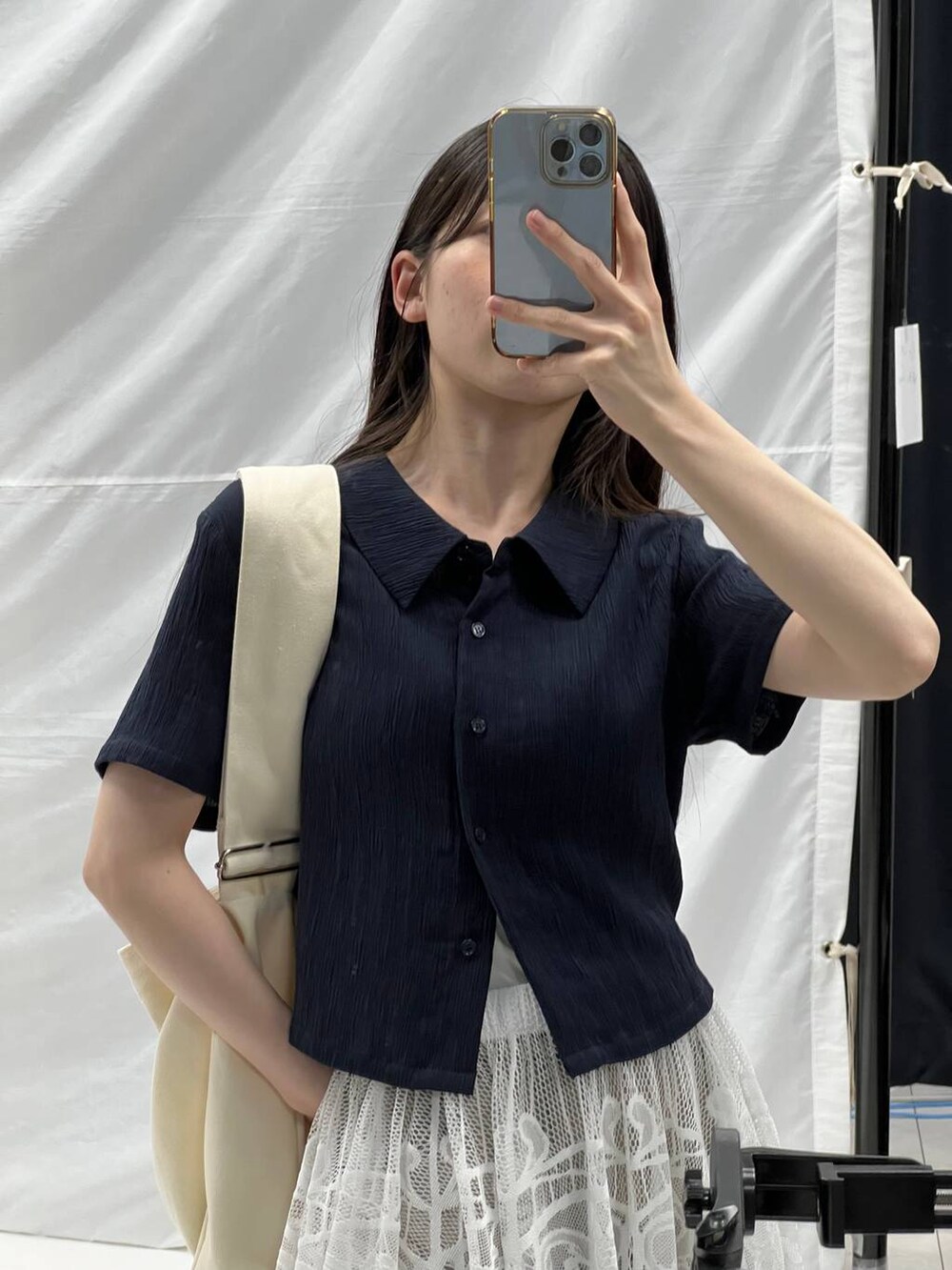 ホワイト系のスカート、ベージュ系のショルダーバッグ、グレー系のデニムパンツを着用したレディースの夏コーディネートの6枚目の写真