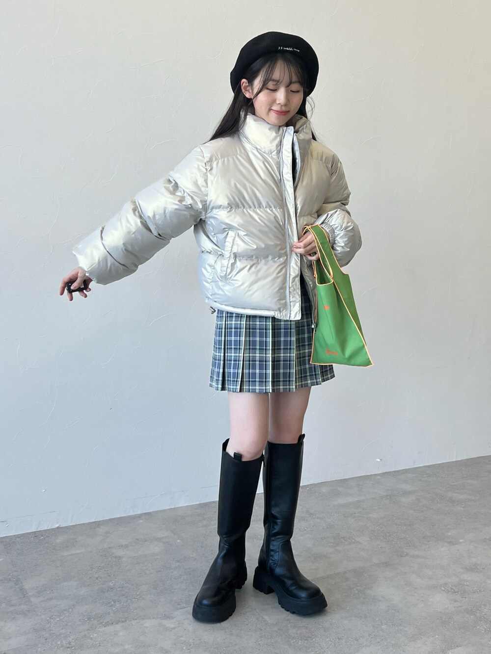 グリーン系のトートバッグ、その他のダウンジャケット/コート、ブラック系のブーツを着用したレディースの秋コーディネートの3枚目の写真