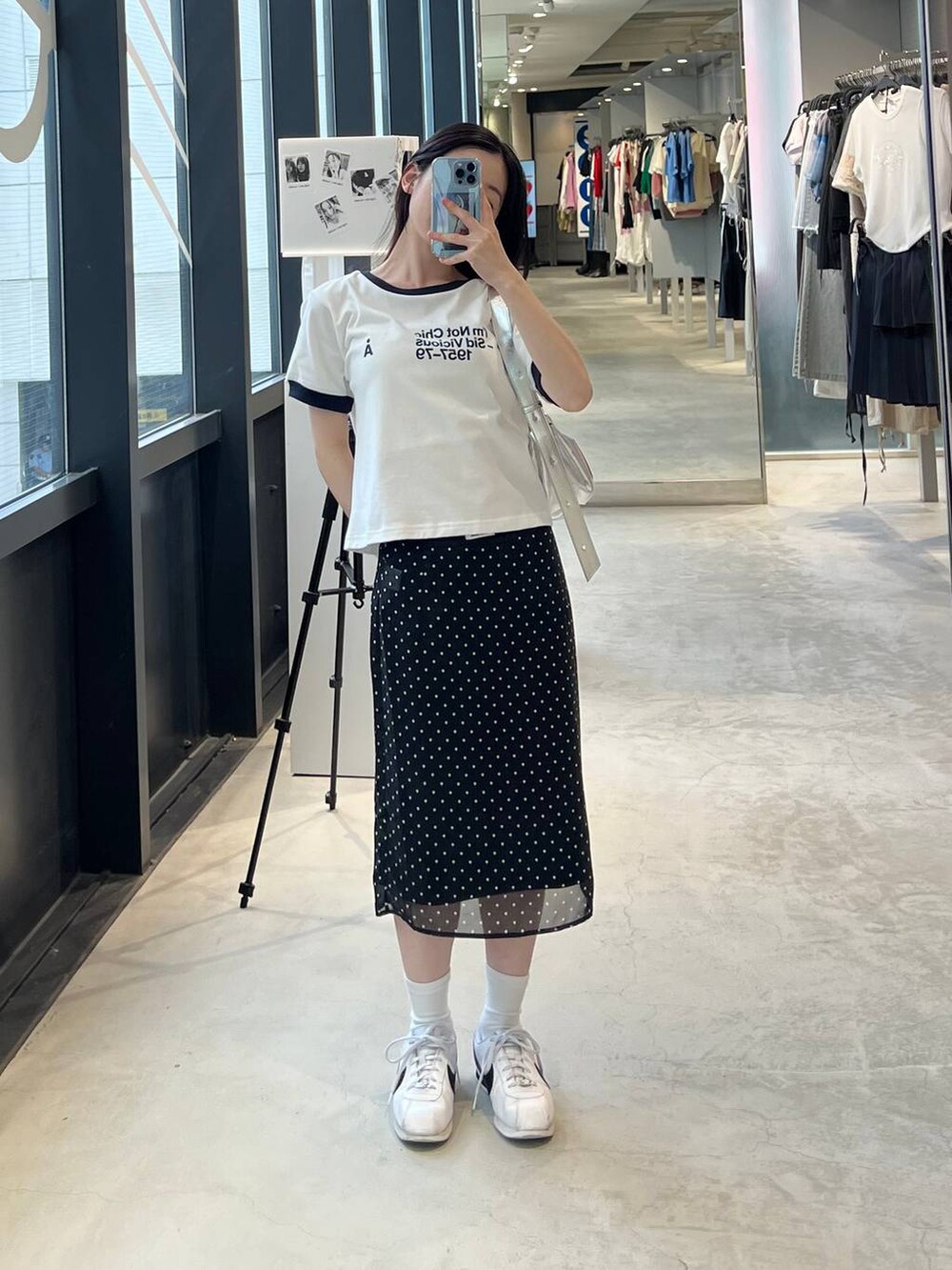 ホワイト系のTシャツ/カットソー、グレー系のトートバッグ、ブラック系のスカートを着用したレディースの夏コーディネートの2枚目の写真