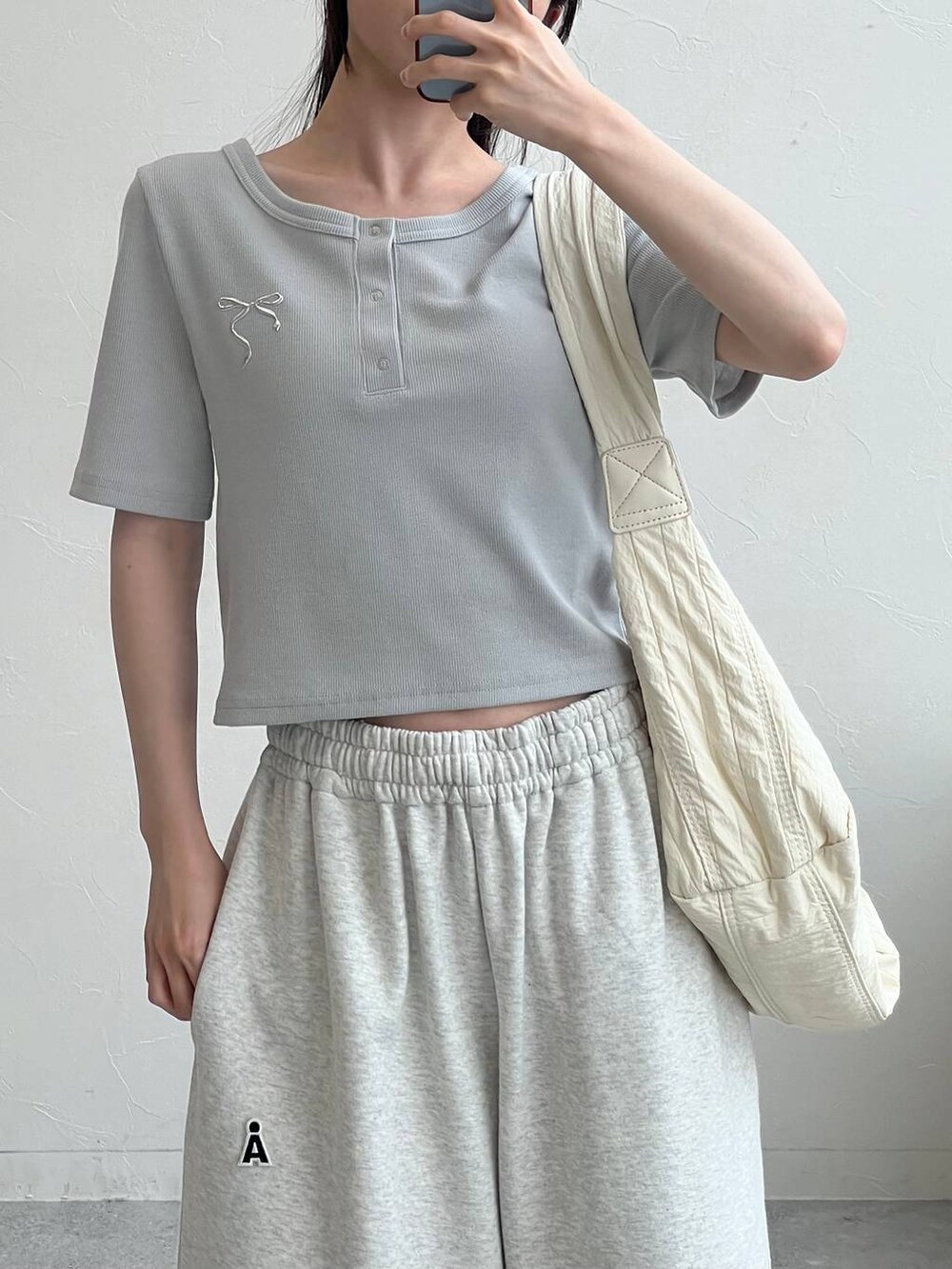 グレー系のスウェットパンツ、ベージュ系のショルダーバッグ、ブルー系のTシャツ/カットソーを着用したレディースの夏コーディネートの5枚目の写真