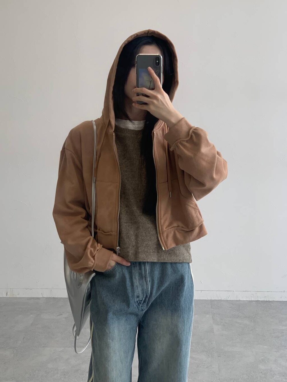 ブラウン系のパーカー、その他のデニムパンツ、グレー系のバックパック/リュックを着用したレディースの秋コーディネートの5枚目の写真