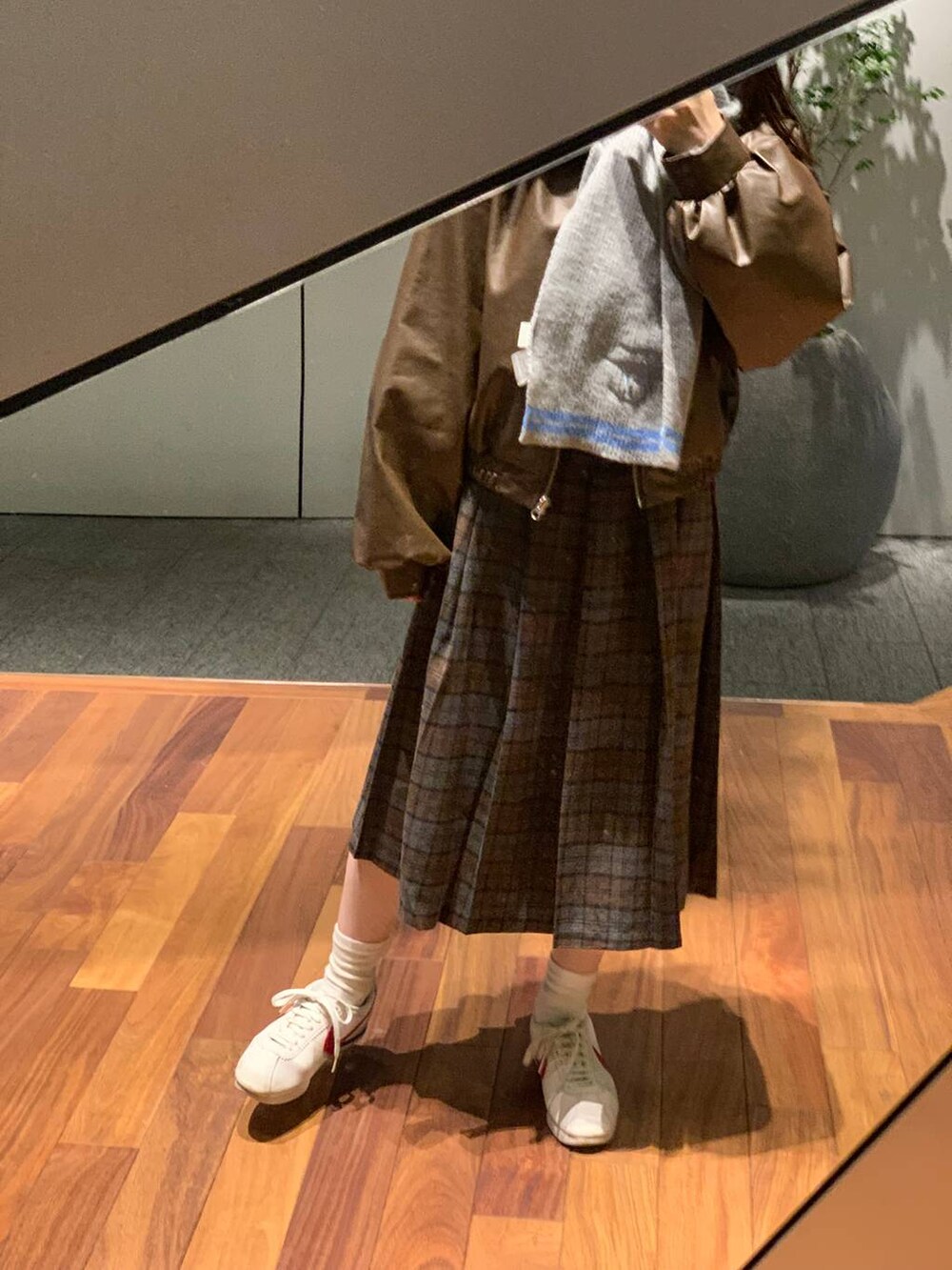 グレー系のカーディガン/ボレロ、ブラウン系のブルゾン、ブラウン系のスカートを着用したレディースの秋コーディネートの4枚目の写真