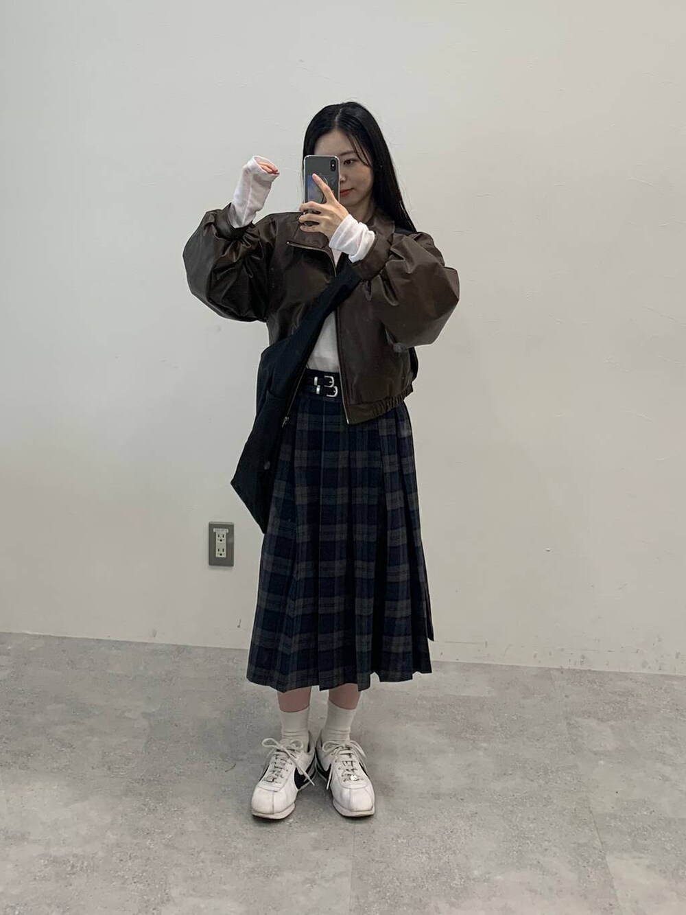 ブラック系のショルダーバッグ、ブラウン系のブルゾン、グレー系のスカートを着用したレディースの秋コーディネートの3枚目の写真