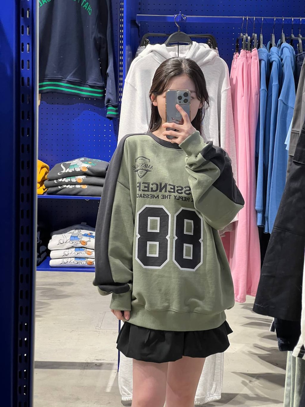 ブラック系のスカート、グリーン系のスウェットを着用したレディースの春コーディネートの5枚目の写真