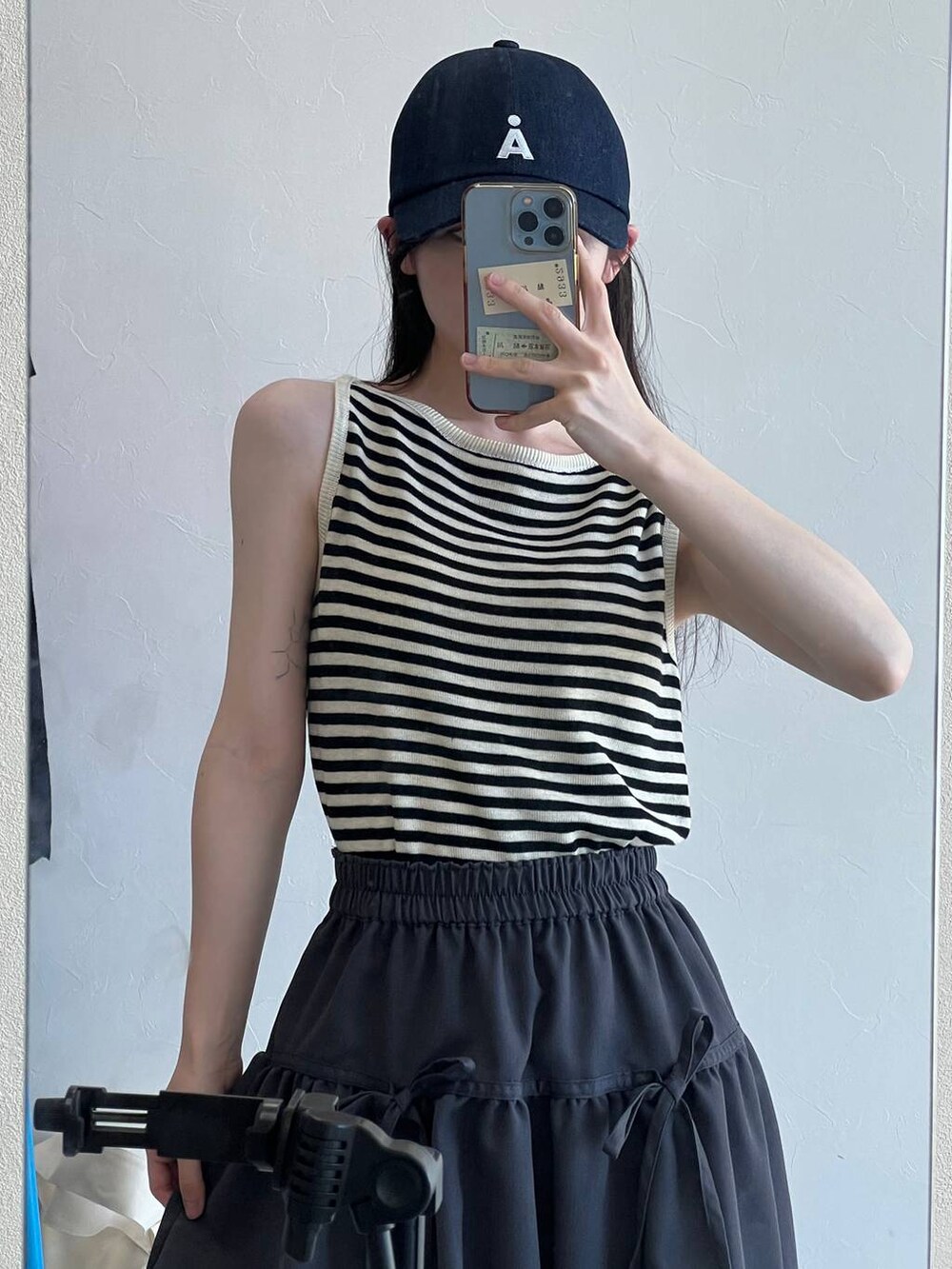 ベージュ系のTシャツ/カットソー、ベージュ系のショルダーバッグ、グレー系のスカートを着用したレディースの春コーディネートの8枚目の写真