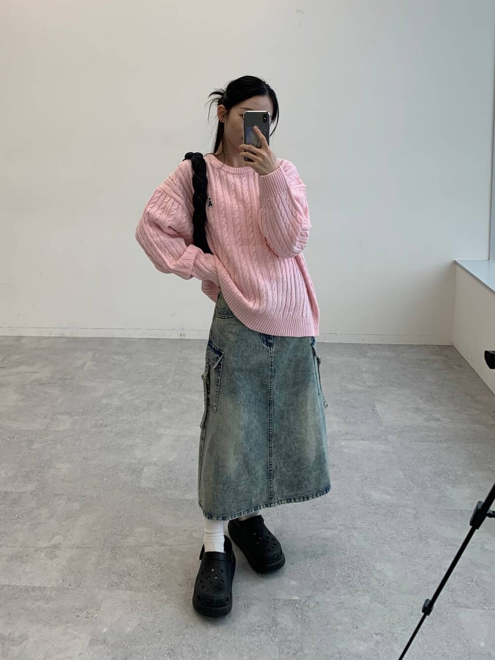 ブラック系のサンダル、ブラック系のショルダーバッグ、ブルー系のデニムスカートを着用したレディースの秋コーディネートの2枚目の写真