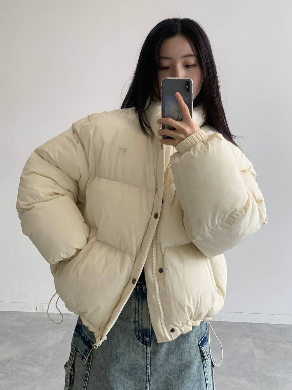 ブルー系のデニムスカート、ベージュ系のダウンジャケット/コートを着用したレディースの秋コーディネートの9枚目の写真