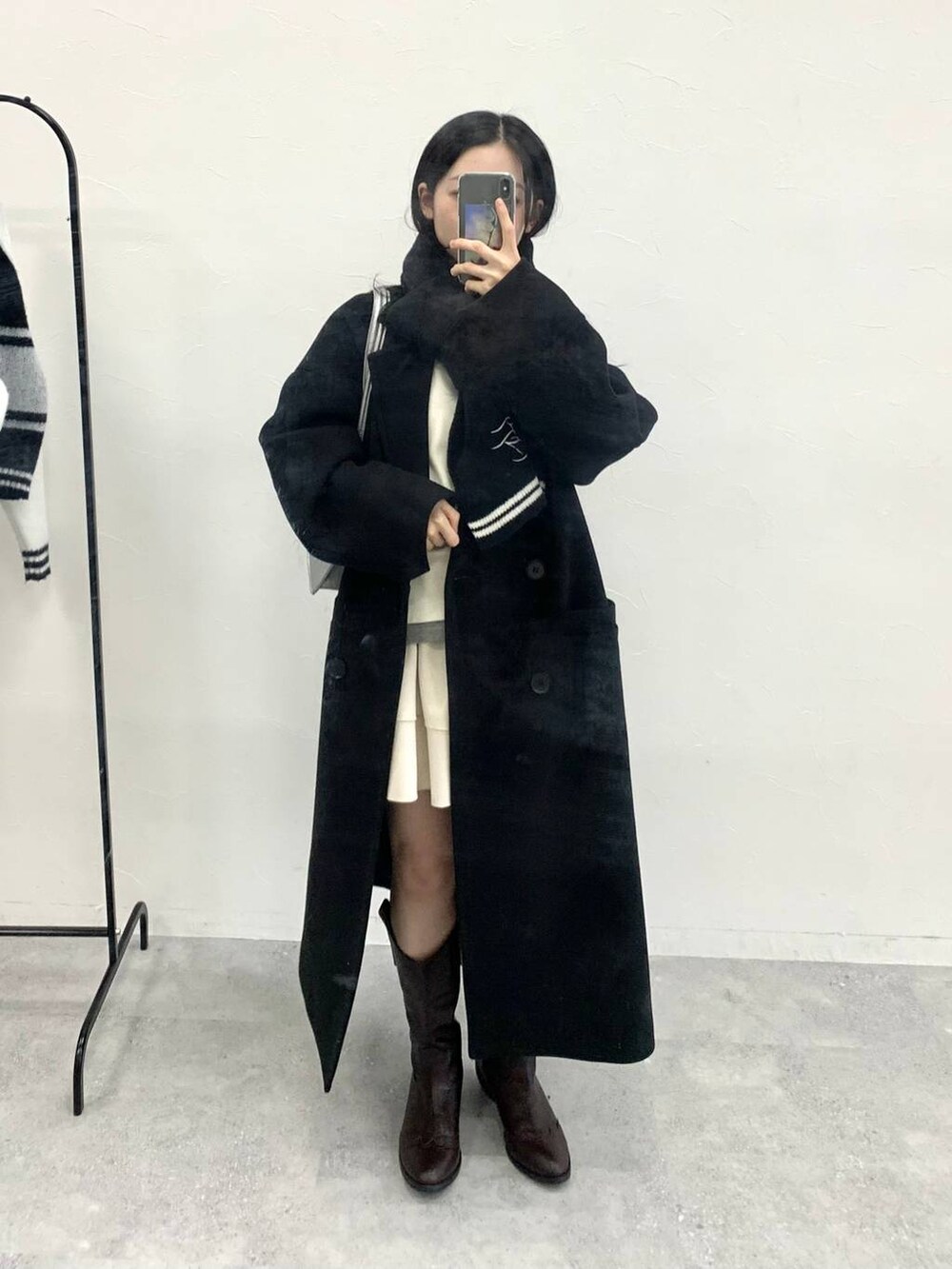 シルバー系のショルダーバッグ、ベージュ系のTシャツ/カットソー、ホワイト系のスカートを着用したレディースの冬コーディネートの2枚目の写真