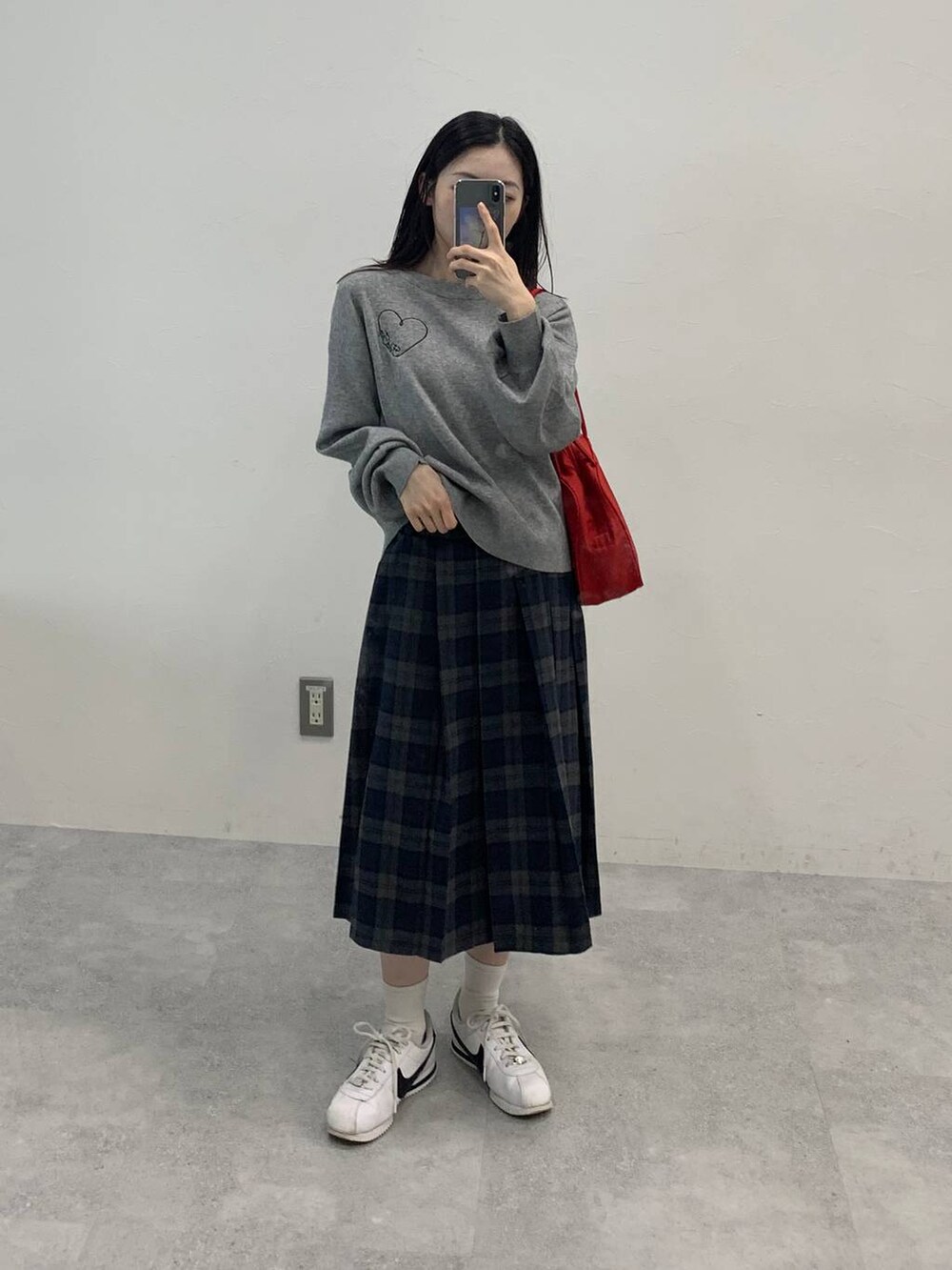 グレー系のニット/セーター、グレー系のスカートを着用したレディースの秋コーディネートの3枚目の写真
