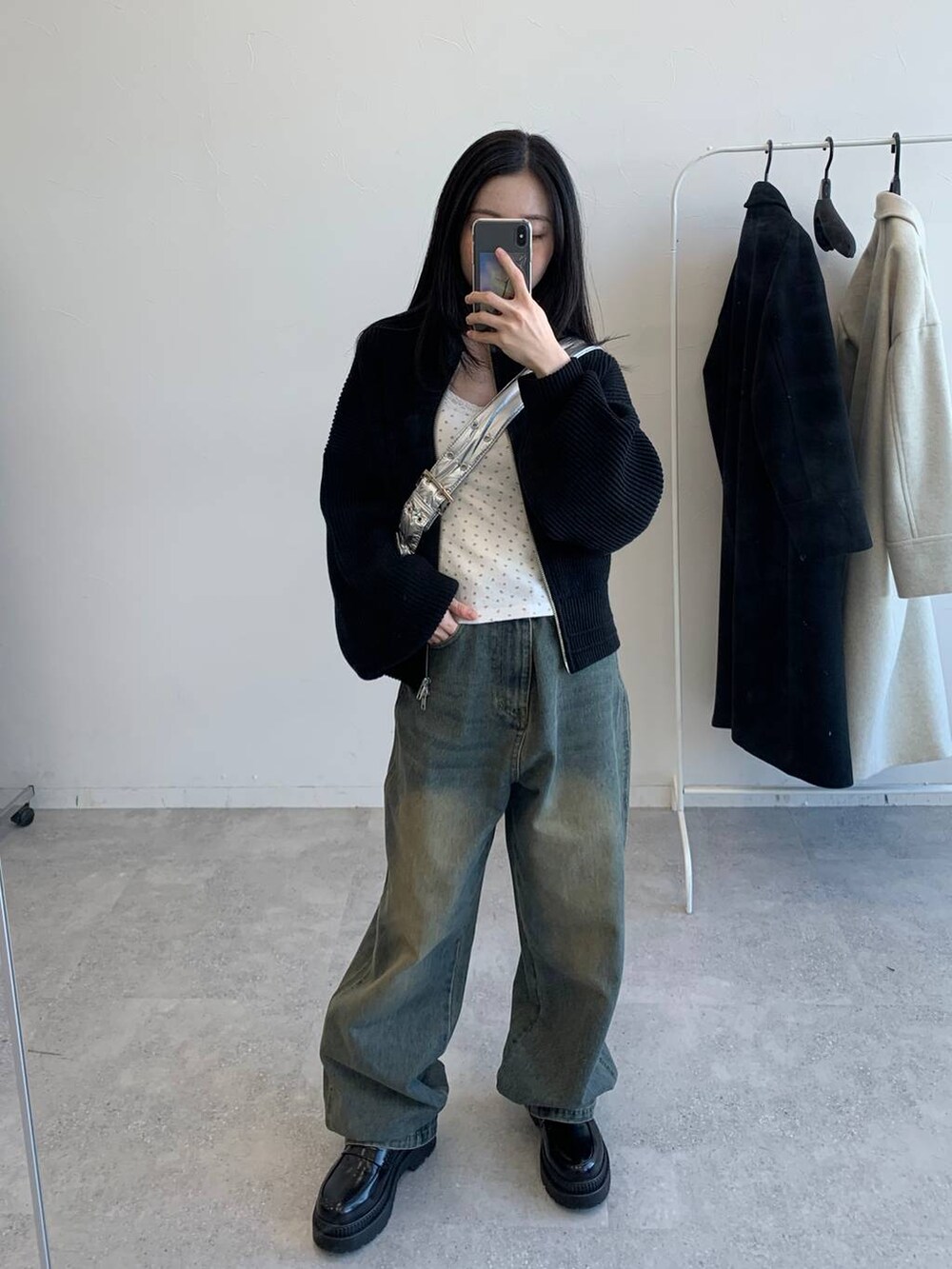 その他のショルダーバッグ、ブラック系のブルゾン、ブルー系のデニムパンツを着用したレディースの冬コーディネートの6枚目の写真