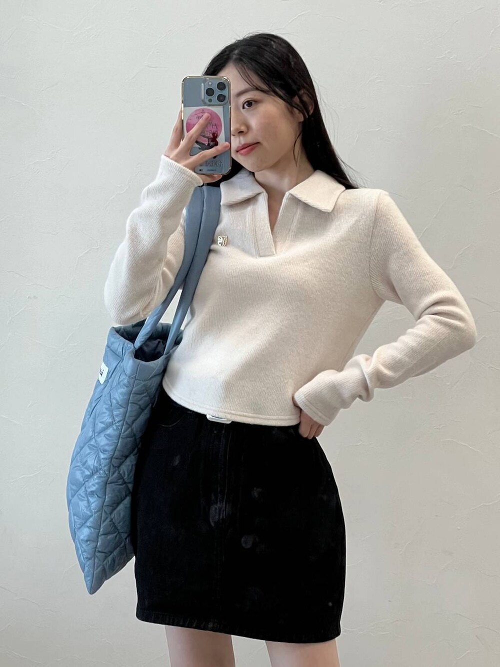 ブラック系のデニムスカート、ブラック系のバレエシューズ、ブルー系のトートバッグを着用したレディースの冬コーディネートの7枚目の写真