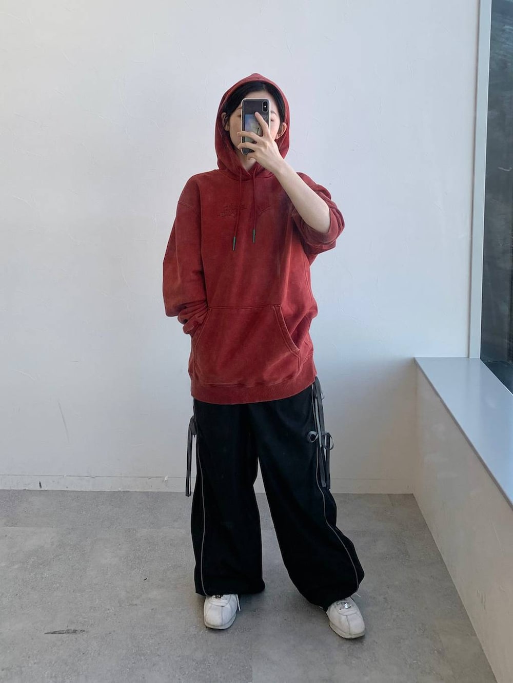 ブラック系のその他パンツ、レッド系のパーカーを着用したレディースの冬コーディネートの4枚目の写真