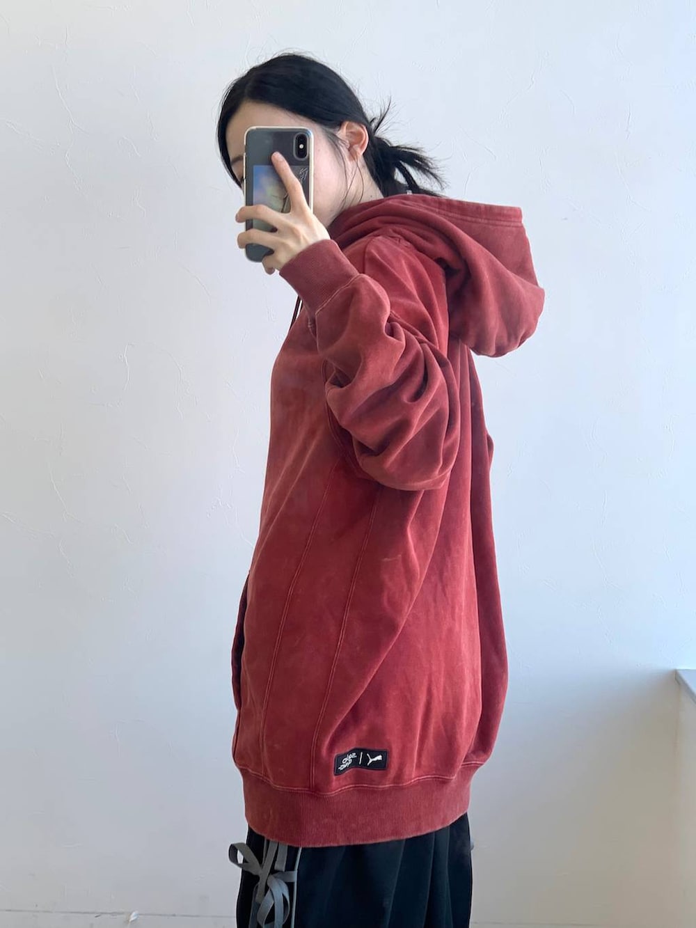 ブラック系のその他パンツ、レッド系のパーカーを着用したレディースの冬コーディネートの7枚目の写真