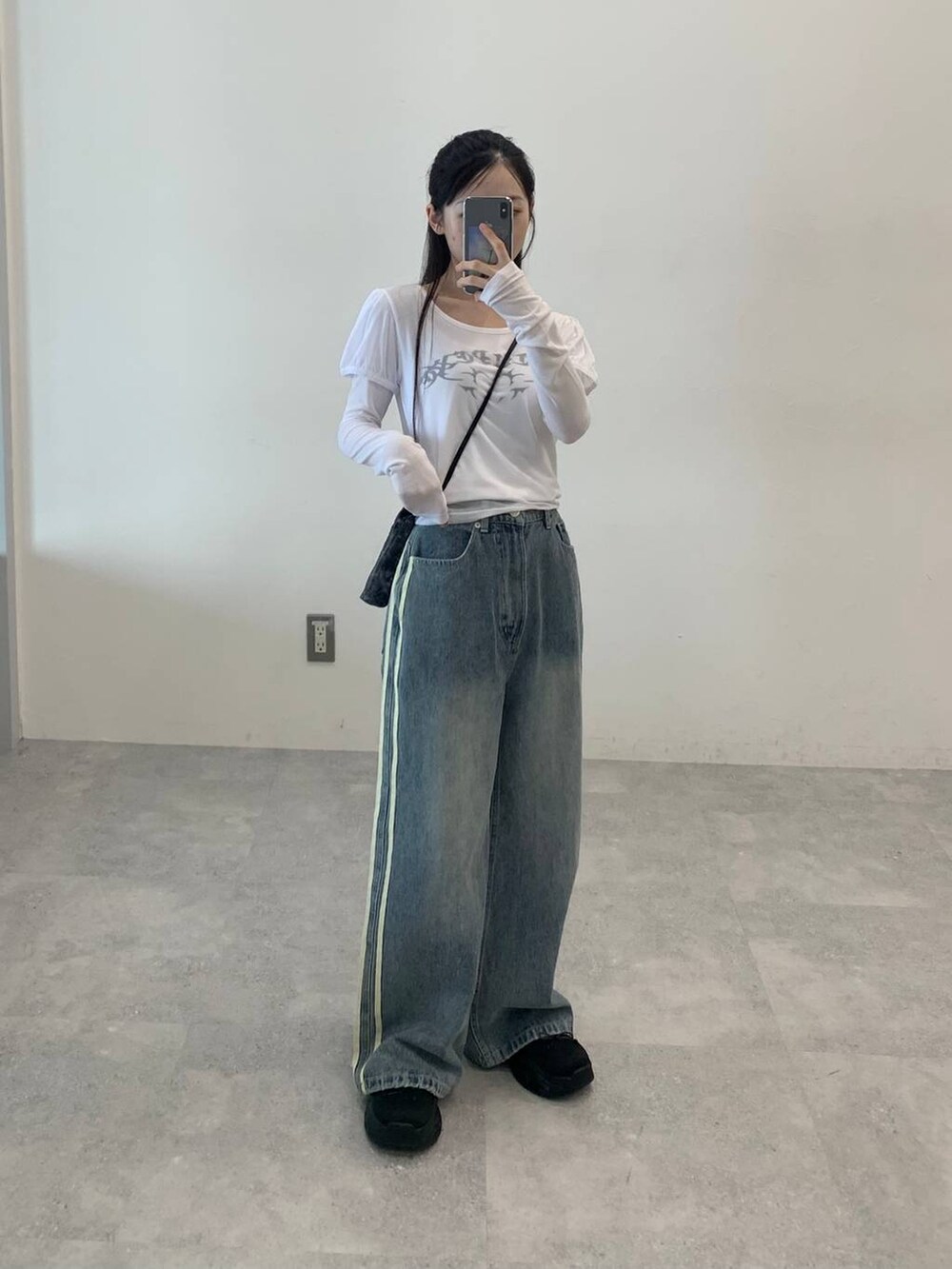 その他のデニムパンツ、ホワイト系のTシャツ/カットソー、ブラック系のショルダーバッグを着用したレディースの秋コーディネートの2枚目の写真