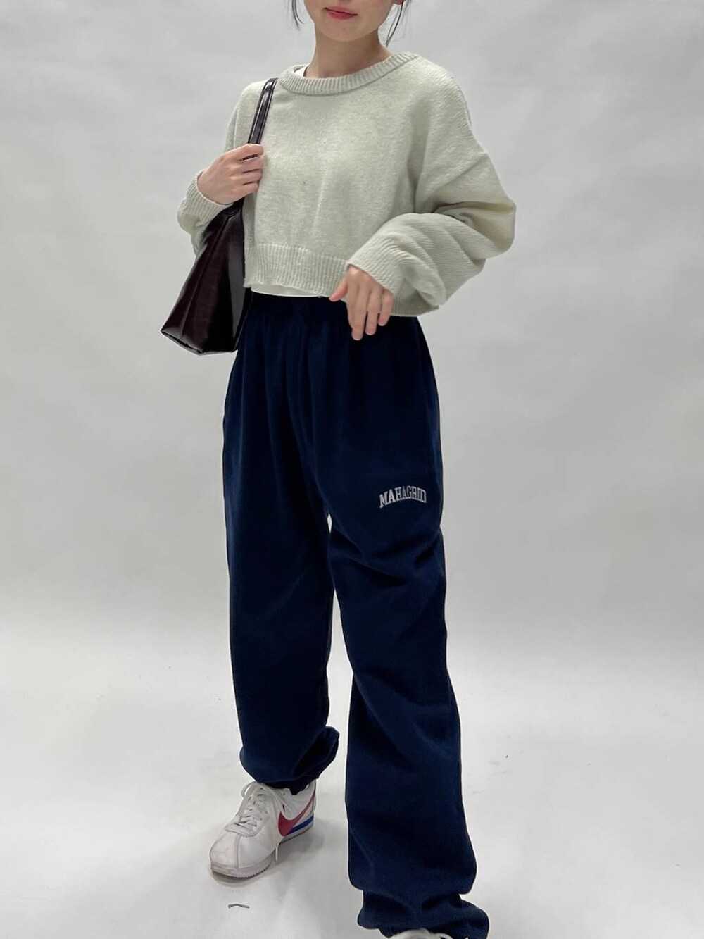 グリーン系のニット/セーターを着用したレディースの春コーディネートの5枚目の写真