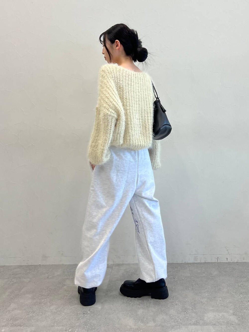 ブラック系のブーツ、ブラック系のショルダーバッグ、ベージュ系のニット/セーターを着用したレディースの冬コーディネートの5枚目の写真