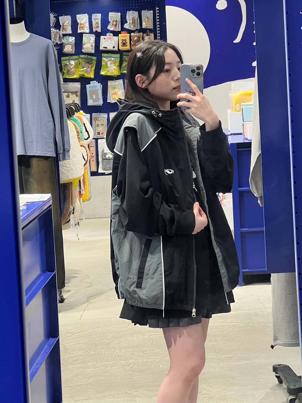 グレー系のスカート、ブラック系のTシャツ/カットソー、ブラック系のナイロンジャケットを着用したレディースの春コーディネートの2枚目の写真