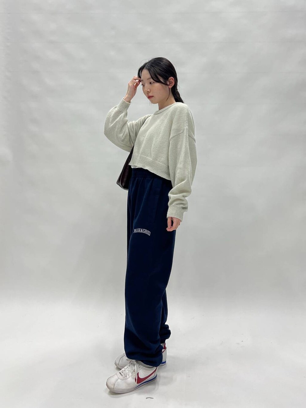 グリーン系のニット/セーターを着用したレディースの春コーディネートの2枚目の写真