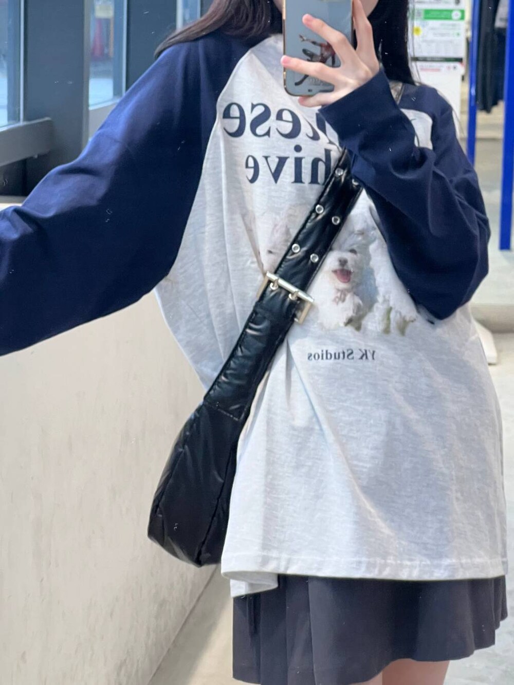 グレー系のスカート、ブラック系のショルダーバッグ、グレー系のTシャツ/カットソーを着用したレディースの春コーディネートの2枚目の写真