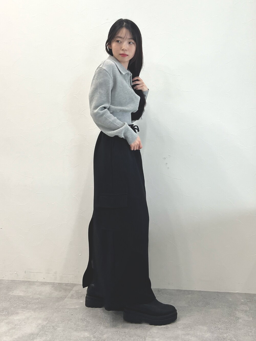 ブラック系のスカート、ブラック系のブーツ、グレー系のTシャツ/カットソーを着用したレディースの冬コーディネートの2枚目の写真