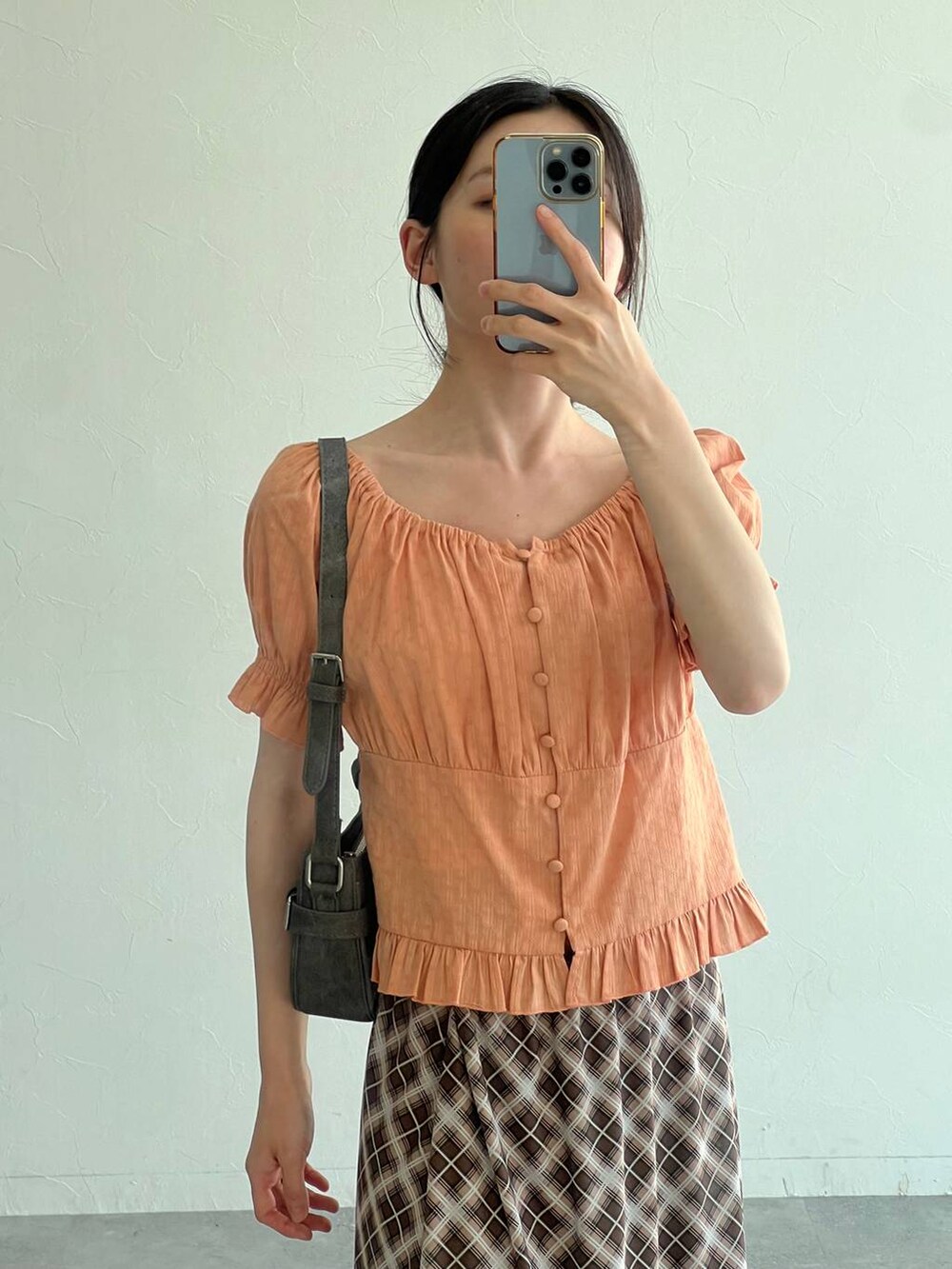 ブラック系のサンダル、オレンジ系のシャツ/ブラウス、ブラック系のトートバッグを着用したレディースの夏コーディネートの7枚目の写真