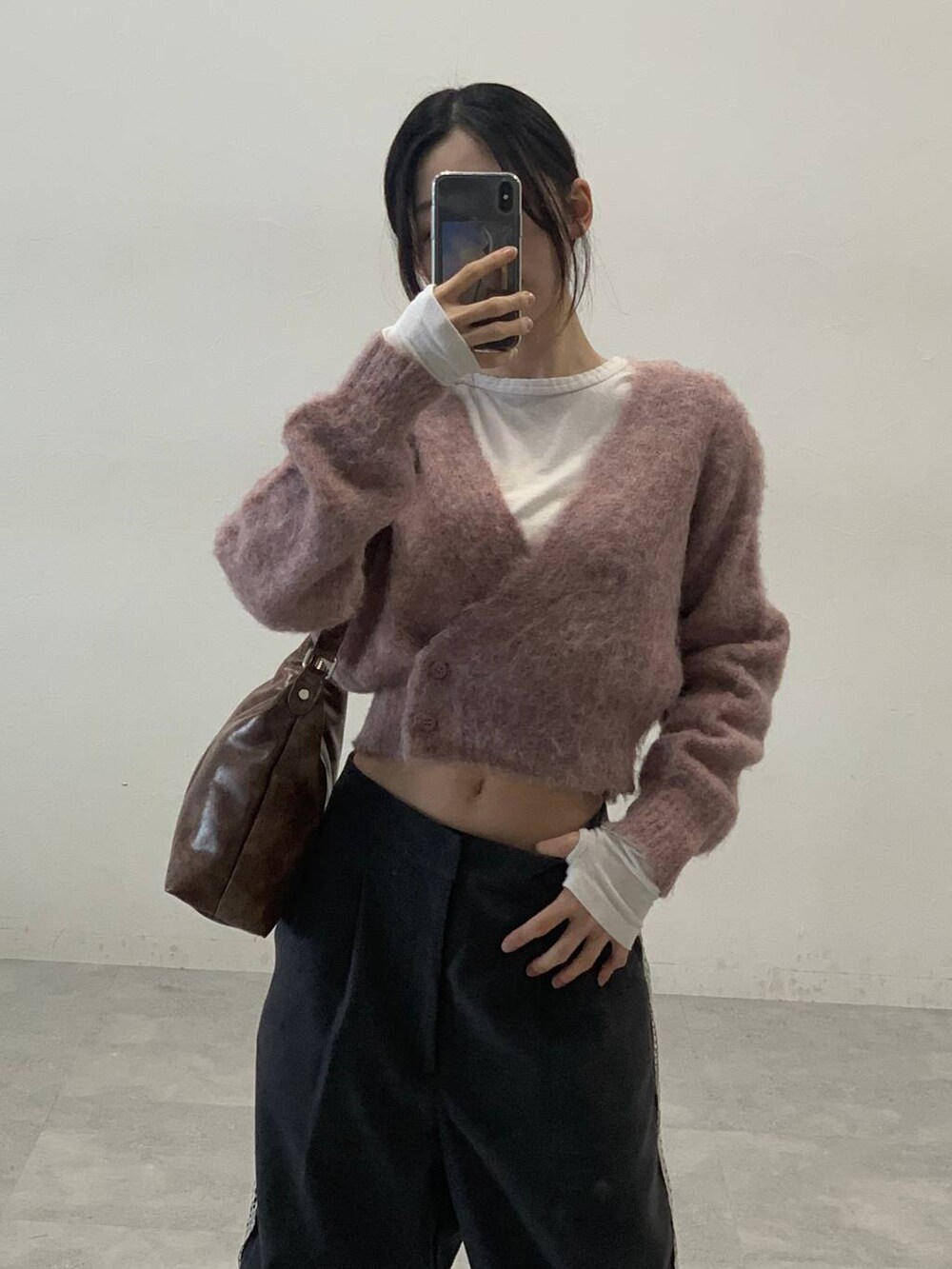 オレンジ系のカーディガン/ボレロ、グレー系のスラックス、ベージュ系のTシャツ/カットソーを着用したレディースの秋コーディネートの5枚目の写真