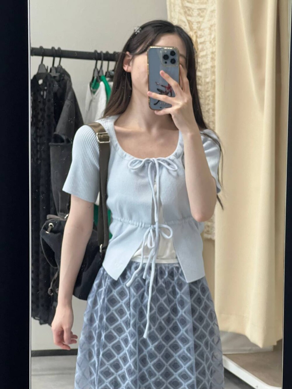 ブルー系のスカート、ブラック系のデニムパンツ、ブルー系のカーディガン/ボレロを着用したレディースの春コーディネートの7枚目の写真