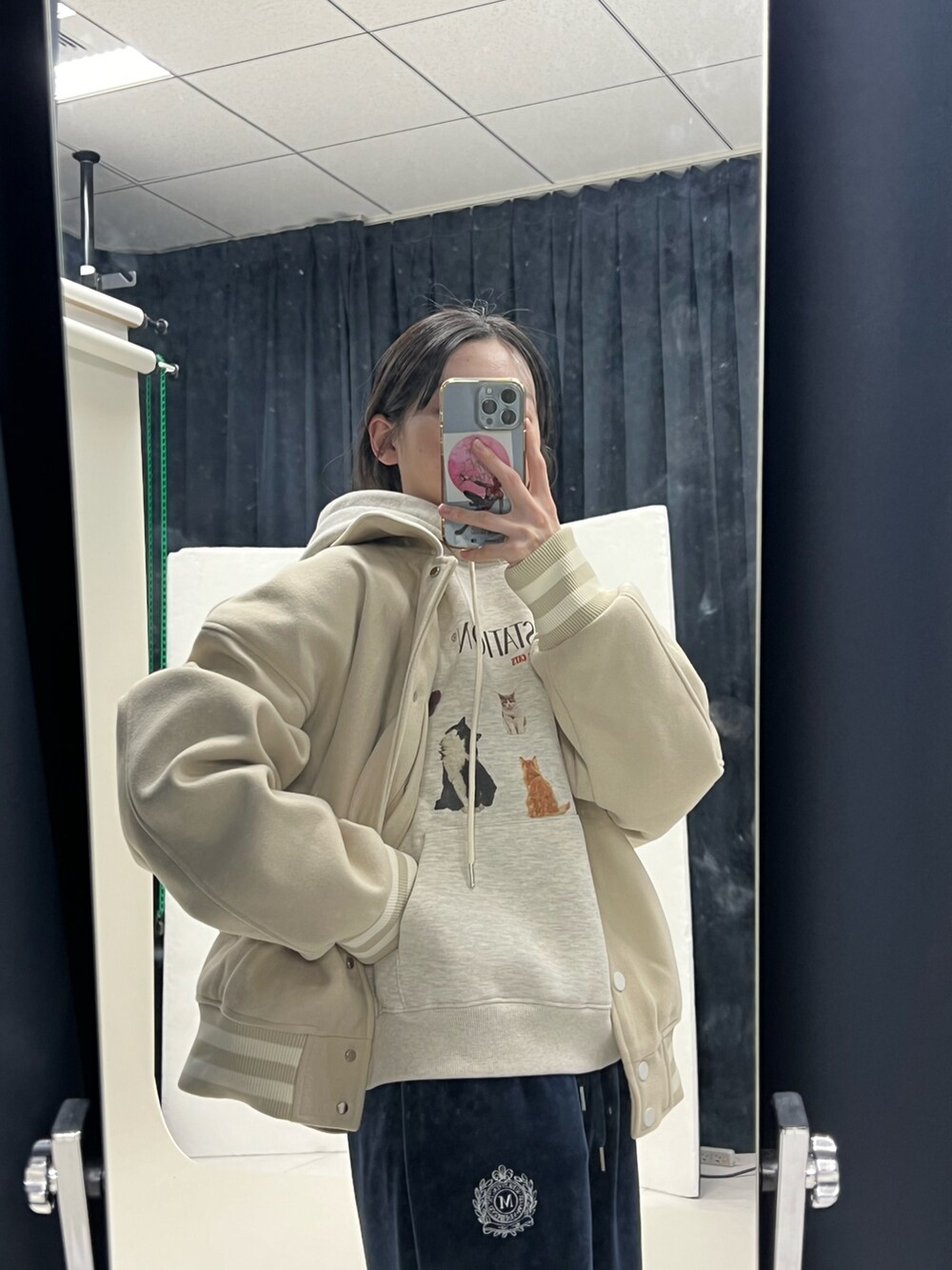 ベージュ系のパーカー、ベージュ系のブルゾン、ブルー系のスウェットパンツを着用したレディースの冬コーディネートの3枚目の写真