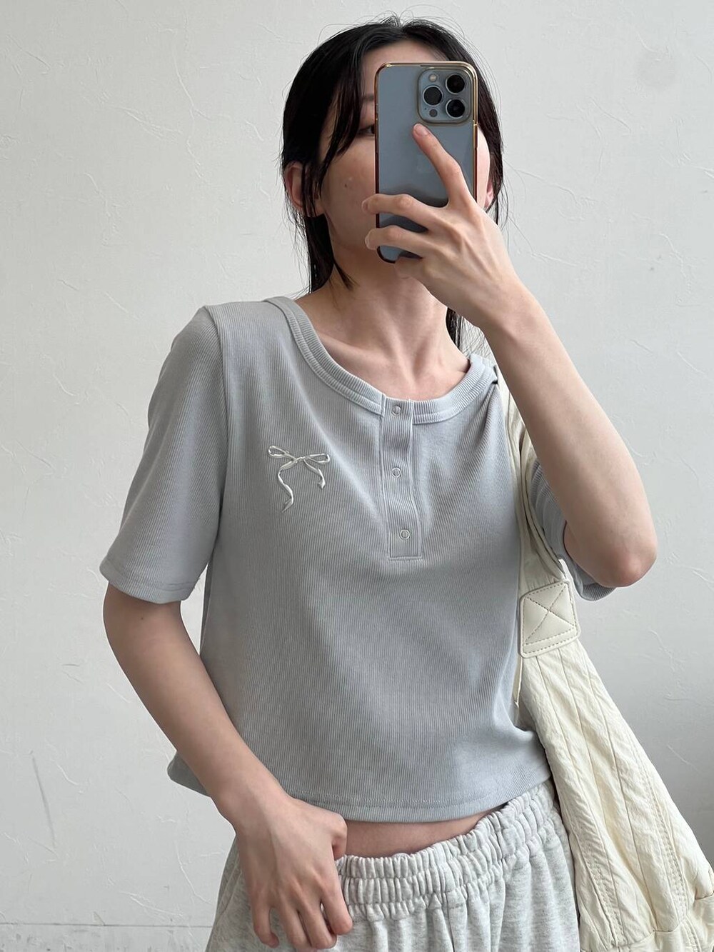 グレー系のスウェットパンツ、ベージュ系のショルダーバッグ、ブルー系のTシャツ/カットソーを着用したレディースの夏コーディネートの4枚目の写真