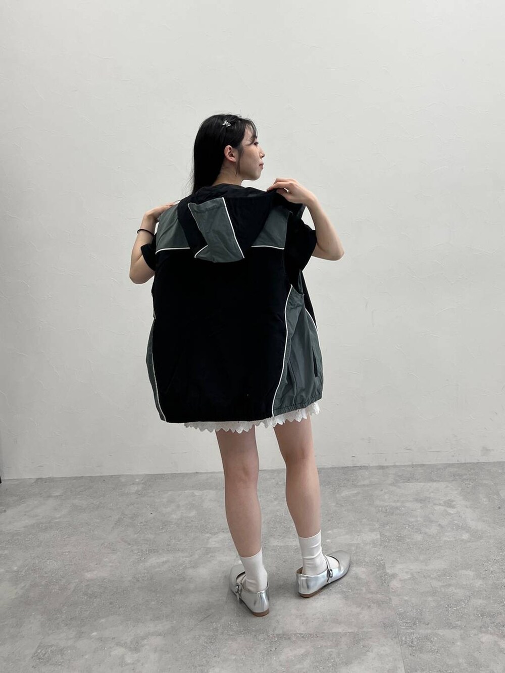 ホワイト系のスカート、ブラック系のナイロンジャケット、ブラック系のTシャツ/カットソーを着用したレディースの春コーディネートの4枚目の写真