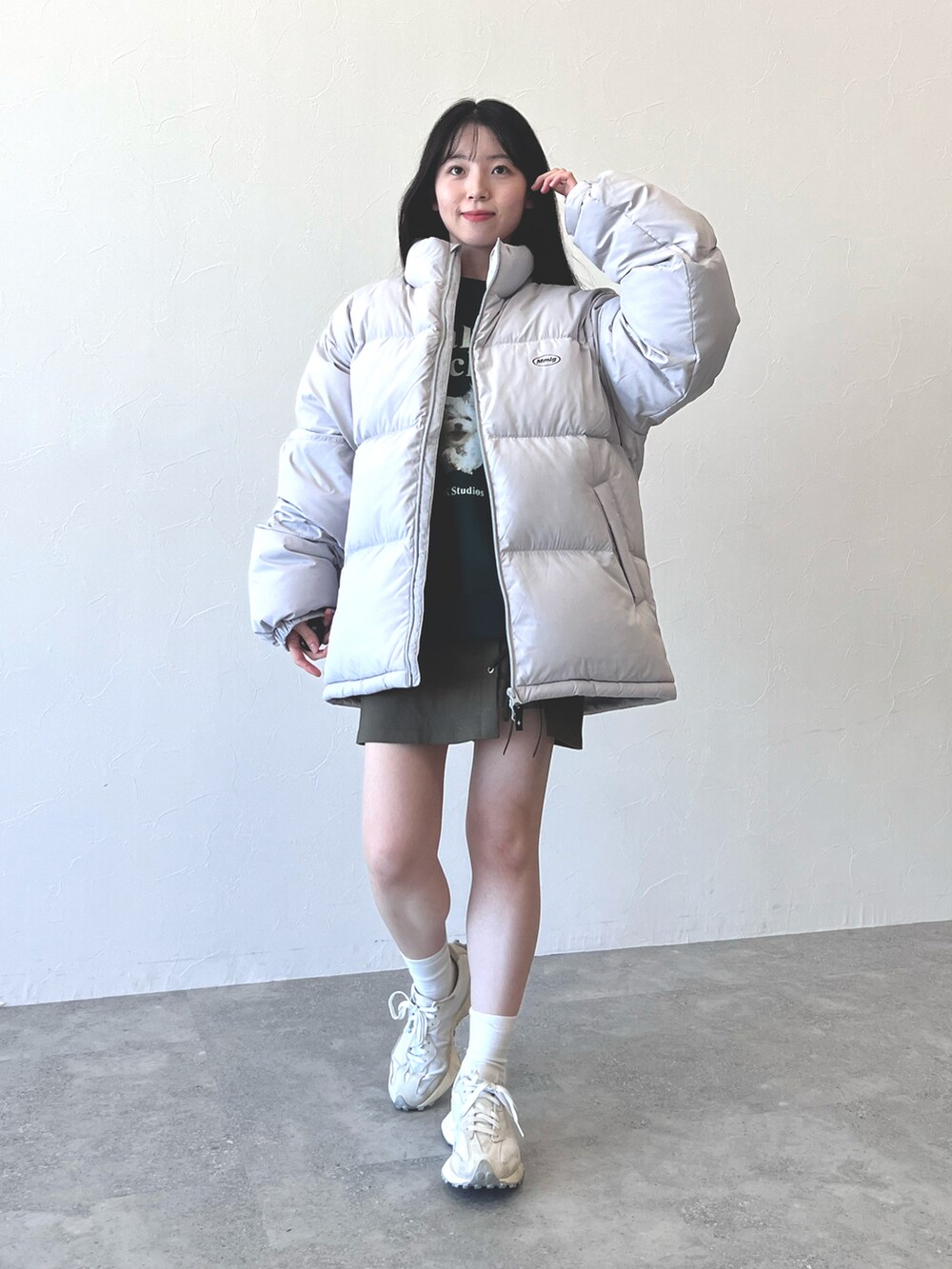 グレー系のダウンジャケット/コート、グリーン系のスカート、ホワイト系のスニーカーを着用したレディースの冬コーディネートの4枚目の写真