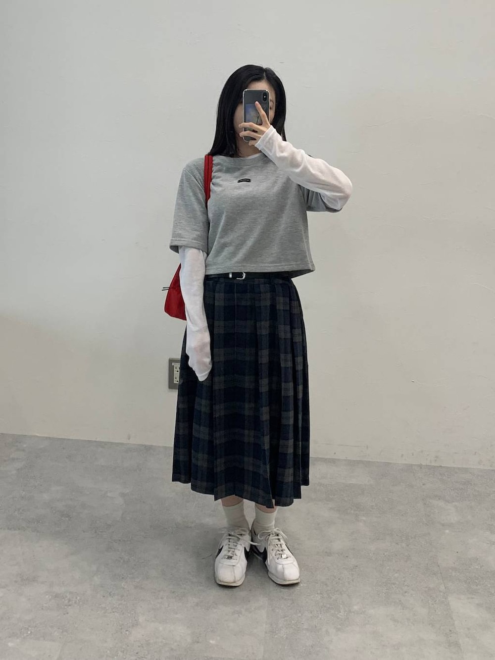 グレー系のスカート、ホワイト系のTシャツ/カットソーを着用したレディースの秋コーディネートの2枚目の写真