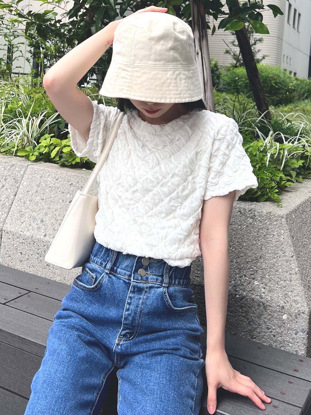 ホワイト系のTシャツ/カットソー、ホワイト系のバッグ、ブルー系のデニムパンツを着用したレディースの夏コーディネートの2枚目の写真