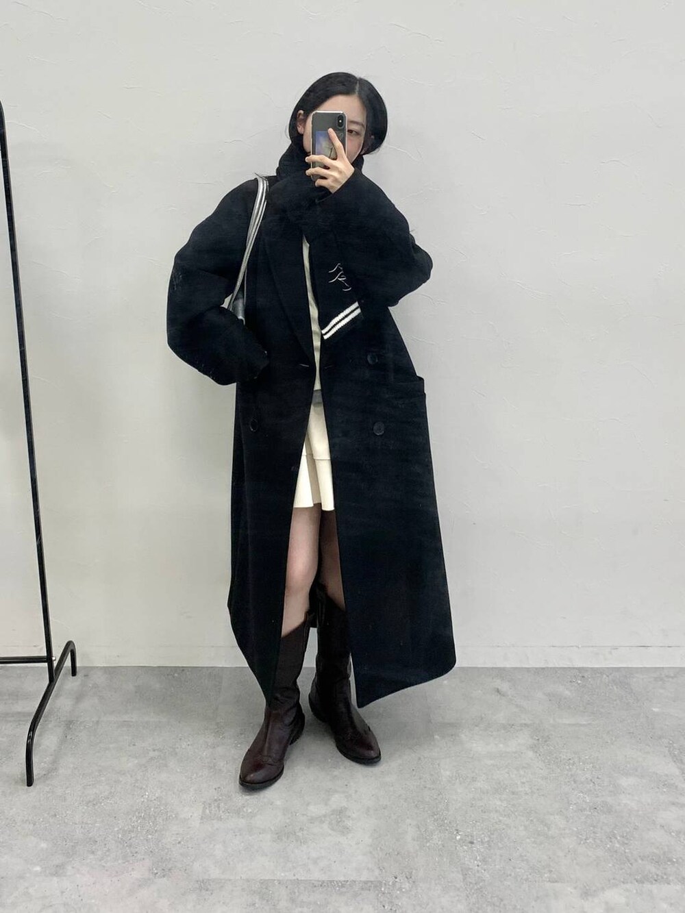 シルバー系のショルダーバッグ、ベージュ系のTシャツ/カットソー、ホワイト系のスカートを着用したレディースの冬コーディネートの3枚目の写真