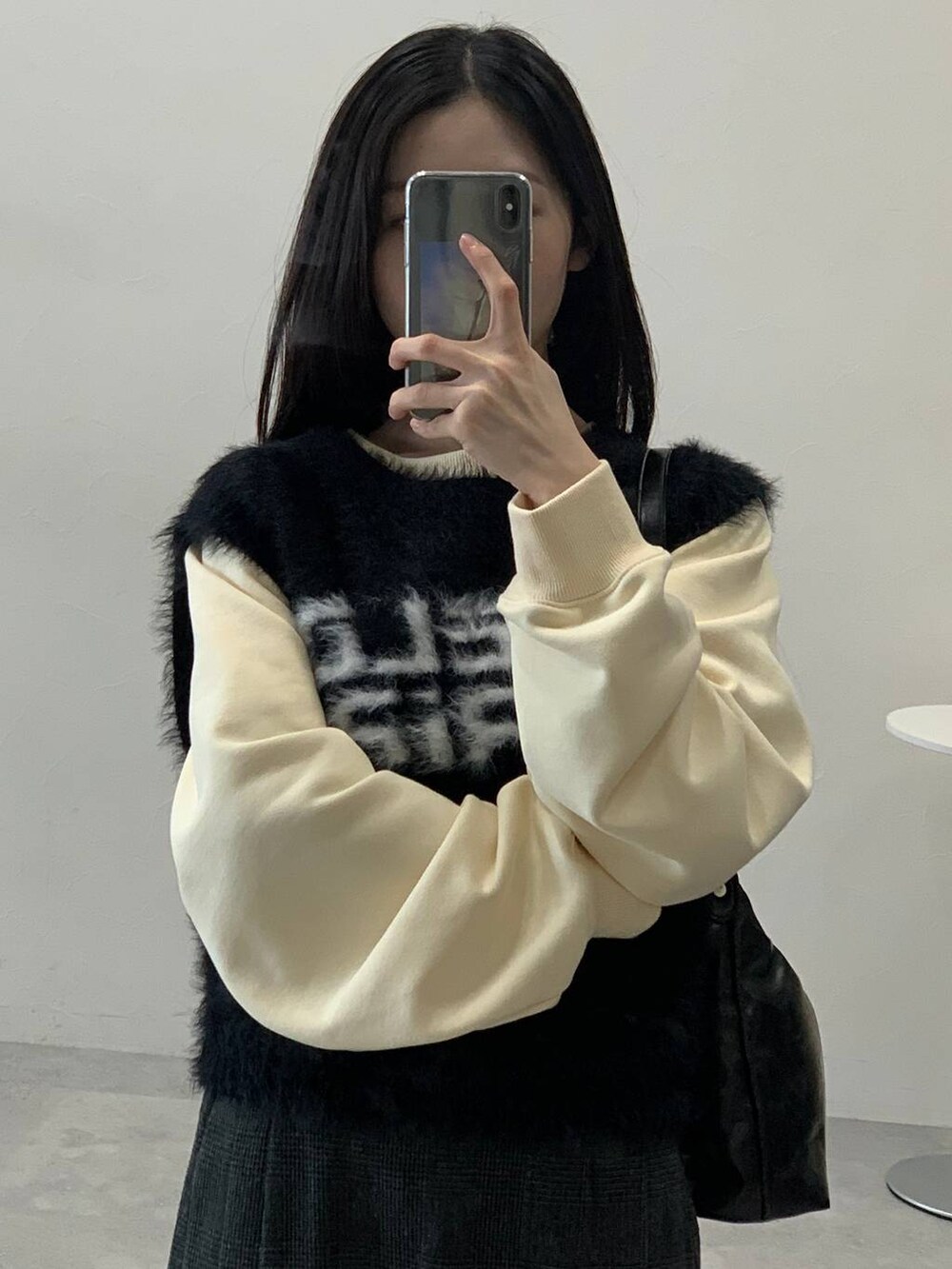 ベージュ系のスウェット、グレー系のスカート、ブラック系のハンドバッグを着用したレディースの冬コーディネートの7枚目の写真